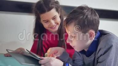 男孩和女孩在室内玩平板电脑。 <strong>兄妹</strong>儿童社交媒体在线游戏平板电脑